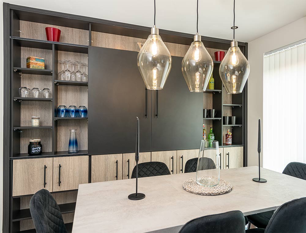 dining area with media wall and shelving with glasses in it