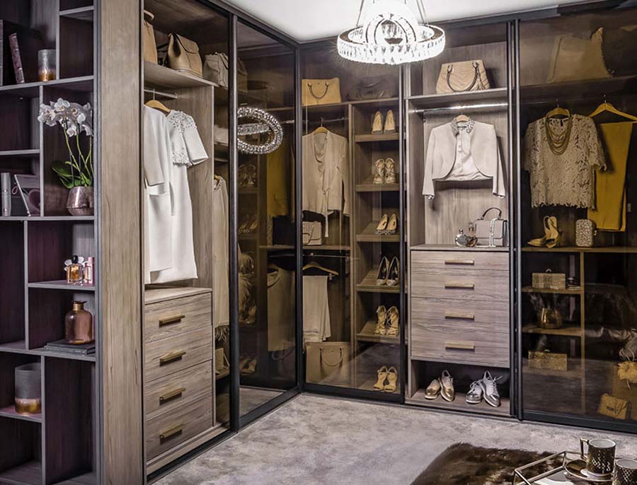 clear glass sliding wardrobe with woman's clothes inside