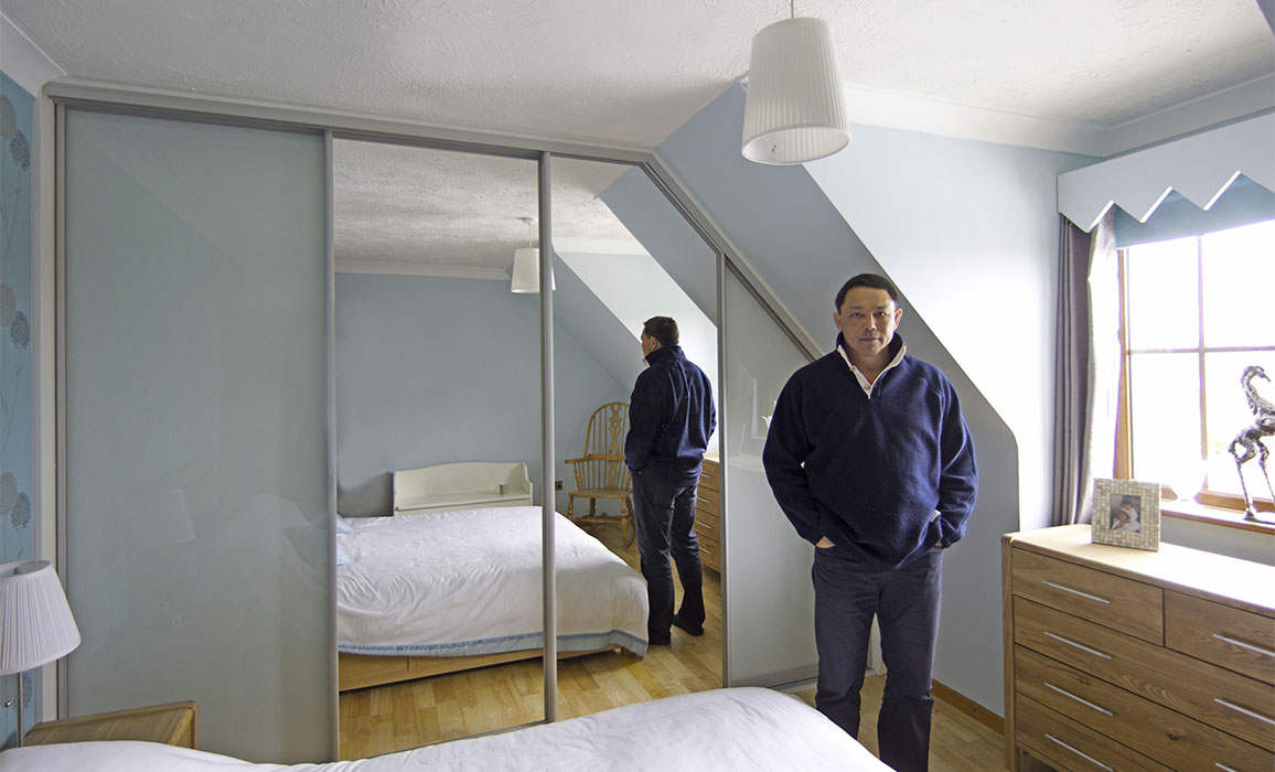 rory underwood standing beside his angled sliding wardrobe